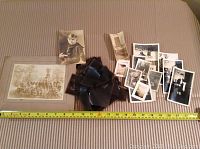 Full view of assortment including mounted group photo, individual portrait photos, and multiple film negatives spread out on cloth surface with measuring tape showing approx dimensions