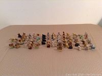 Wide shot of all 72 Wade nursery rhyme animal ceramic figurines arranged in multiple rows on a fabric surface, showing various colors and styles.