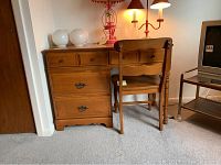 Desk with two smaller upper drawers and two larger lower drawers. Brass pulls on drawers. Medium-tone wood. Lamp and other decorative items on desk top.