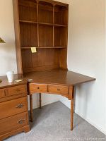 Two-piece corner desk and bookcase set made of wood with turned legs and drawers.