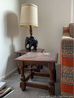 Pair of wood side tables next to an upholstered sofa, with wooden elephant lamp on one table, showing size, condition, and lamp placement.