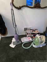 Side angle of Bissell fabric cleaner, Shark hand vacuum, Shark floor cleaner, and extra mop cloths shown with packaging