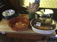 Overview of the lot showing Magnawave microwave roaster, ceramic flan pan, frying pans, sauté pans, and wooden utensils.