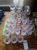Top view showing rows of clear crystal stemware with intricate cut patterns including water, red wine, and brandy glasses.