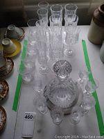 Overview of all stemware and decanter on table, showing variety of glasses and decanter with stopper at center.