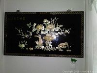 Front view of entire lacquered wall hanging with floral, cherry blossoms, and koi fish scene on black background.