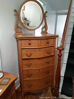 Front view of dresser with attached oval mirror