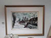 Framed acrylic painting featuring Notre Dame Cathedral and bookstalls, taken from a slight angle revealing the matte and frame.