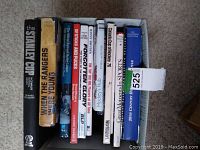 Front view of 11 assorted hockey and sports books arranged vertically in a container.
