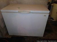Full exterior view of white Kenmore chest freezer with minor wear marks and top lid.