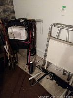 Photo showing multiple walking sticks and canes, Honeywell vaporizer on a chair, and part of a walker frame.