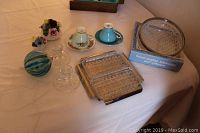 Wide shot of table showing multiple items: teacups, cut glass trays, friendship ball, candlesticks