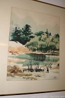 Framed watercolour painting signed VG, showing trees and a water body with earthy tones.