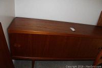 Front view of teak sideboard showing sliding doors and tapered legs