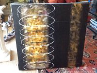 Front view of the abstract painting on canvas showing the gold, white, and black spiral designs, with some reflections visible.
