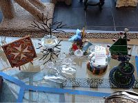 Overview of the 10 items including glass candle holders, bird statue, snow globe, and decorative plaque on a glass table.