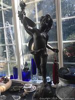 Front view of cherub statue on kitchen counter with window background