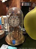 Wide view of the full 8x12 inch Welby anniversary clock encased in glass dome on brass base, with winding key inside.