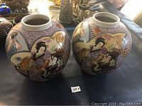 Two large Asian ginger jar vases shown side by side on a table.