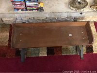 Top-down view of wooden seat showing inner surface and ends of the vintage carriage bench.