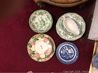 Mixed vintage dishes shown on carpet with floral patterns and desserts ware included.