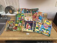Vintage comic books spread out on a counter, showing front covers with characters including Yosemite Sam, Porky Pig, Mickey Mouse, and Richie Rich.