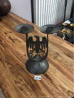 Full view of the antique metal candelabra showing the eagle design and candle holders on a wooden table.