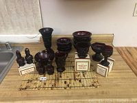 Overview of entire lot displayed on a countertop showing all items including boxed salt and pepper shakers, sugar bowl, wine goblet, various bowls, mug, and vase.
