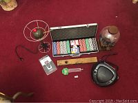 Top view showing entire lot on carpet including poker set, radio, bar decor, martini light, Suunto foot pod, beer tap, and spirit level