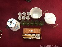 Photo of the entire lot showing enamel teapot, punch bowl, Pyrex dish, green tumblers, and Norpro pastry set in box.