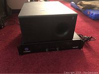 Side view of the Bose speaker sitting on top of the Crown amplifier showing overall size and design.