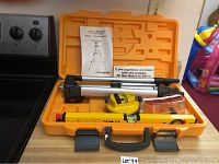 Laser level kit including tripod, yellow laser level, safety glasses, and carrying case.