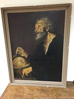 Full view of framed oil painting showing an older man holding a globe in a dark, muted palette.