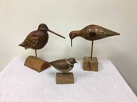 Front view of three wooden bird decoys mounted on wooden bases, showing size and coloration.