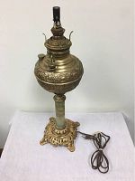 Front view of the antique Miller oil lamp base converted to electric with visible embossed brass reservoir and decorative base.