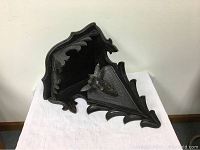 Full view of dark wooden corner shelf with ornately carved edges and mounted deer head detail on triangular plaque, showing overall item condition and design.