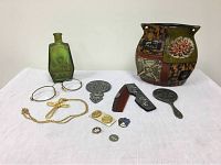 Full lot showing green bottle, vanity set comb and mirror, golden cross necklace, various pins, and decorative Paris vase.