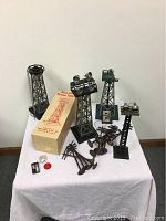 Full lot view showing five beacon towers, thirteen telephone poles, original box, and accessories on white cloth