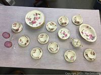 Photo showing all 30 pieces of Castleton China set with floral peony design arranged on a table, including plates, cups, saucers, sugar server, wine glasses and serving bowl.