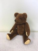 Photo of the teddy bear sitting facing left, showing the jointed limbs and detailed plush fabric.