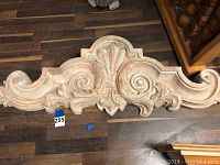 Full frontal view of the decorative cast header showing overall size, shape, and scroll work details with a small tag labeled 255.