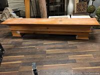 Front view of natural pine wood mantel showing flat top and molding detail with scratches and wear