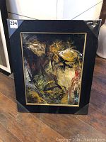 Frontal photo of the framed abstract painting showing the entire piece with black and gold frame.