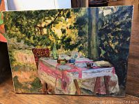 Front view of unframed canvas giclee print depicting outdoor table with tablecloth, bottle, cup, fruit, and green foliage background.