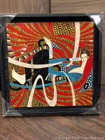 Front view of lacquer art panel in black wood box frame showing the full art design and colors.