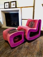 Rocking chair and ottoman on wood floor in front of fireplace