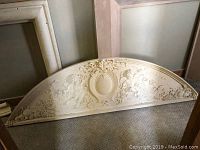 Front view of half-round concrete over-door topper showing full cherub and fruit motif