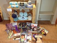 Overview of knitting yarn skeins on a wooden shelf, knitting needles, and an array of knitting books and magazines laid on the floor