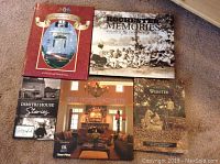 Five books displayed on carpet floor, showing cover art and titles relating to Rochester, NY history and Niagara-on-the-Lake.