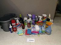 Lot of over 20 cleaning items with bucket, sprays, sponges, and air freshener cans